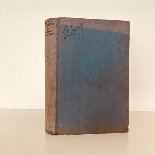 Blue book cover of Rebecca, sunned.